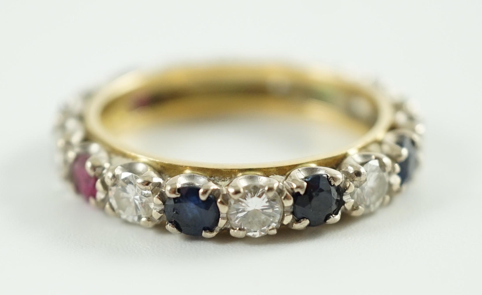 A modern 18ct gold, emerald, sapphire, ruby and diamond set full eternity ring